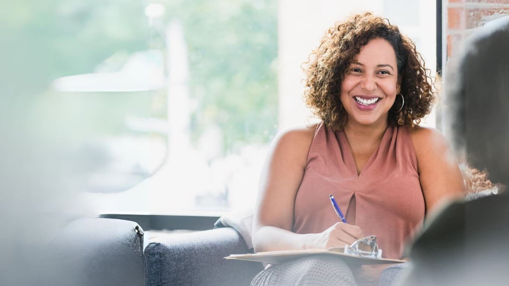 a woman sitting on a couch with a notebook and pen