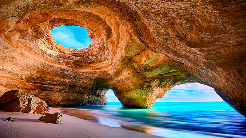 a cave in a cave with a view of the ocean