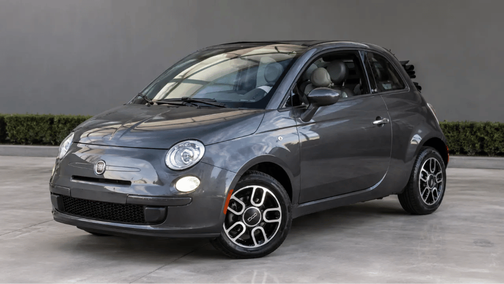 Fiat 500 cinza em showroom externo moderno com fundo neutro e visual premium.