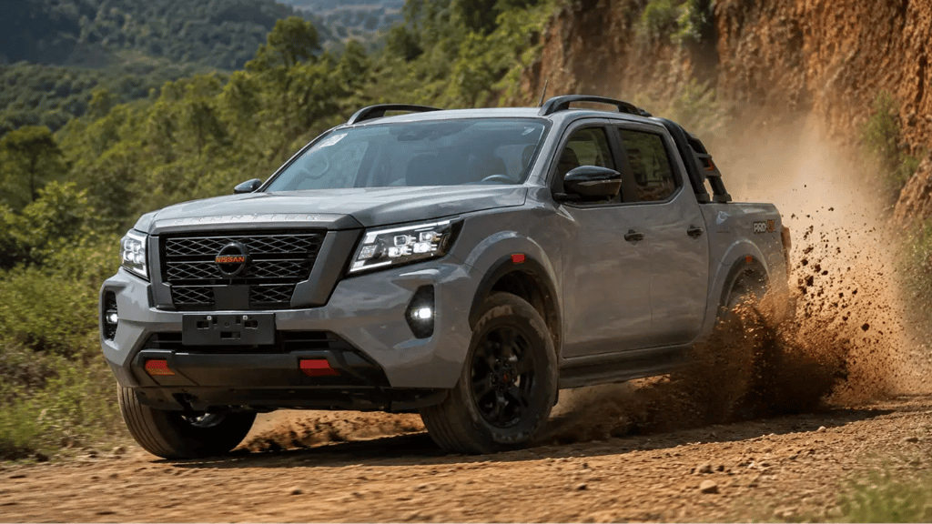 Nissan Frontier PRO-4X em movimento levantando terra em estrada rural