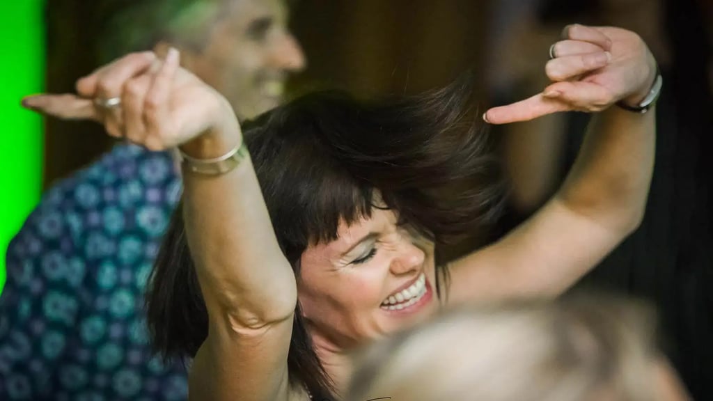 a woman dancing and a man in a blue shirt