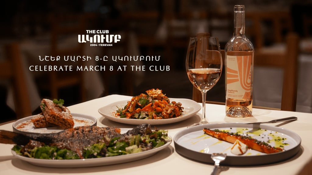 Gourmet dinner plates and a bottle of rose wine at The Club restaurant in Yerevan for March 8th celebration.
