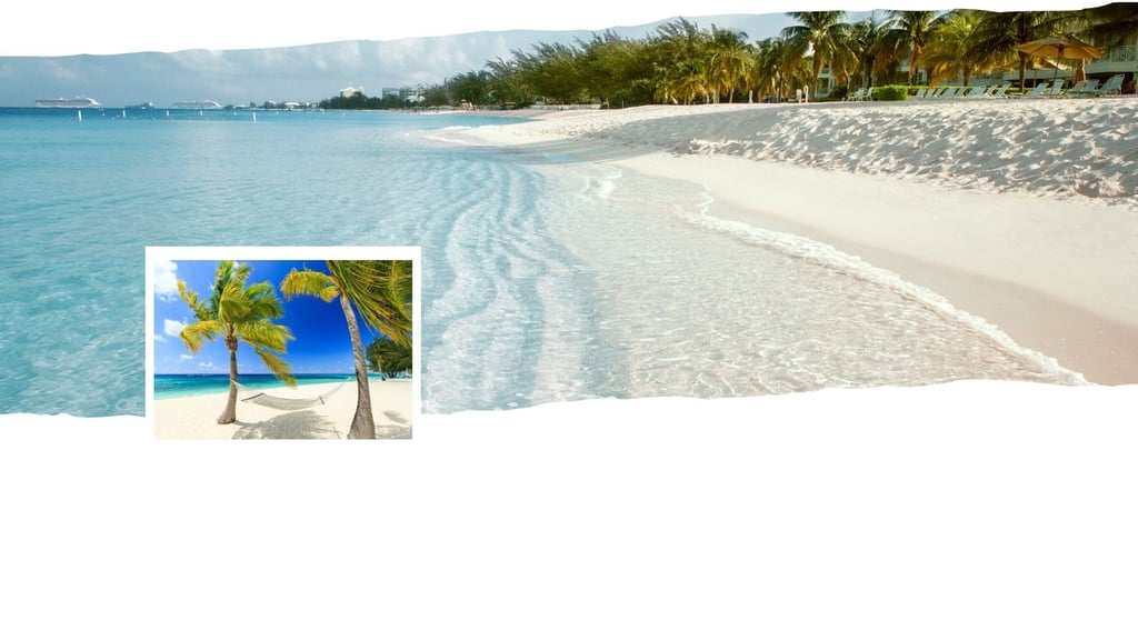 Vista panorâmica de Grand Cayman com mar cristalino, faixa de areia clara e vegetação tropicall.
