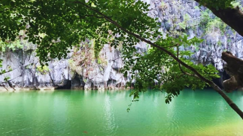 Vista da entrada da caverna com águas claras refletindo a luz.
