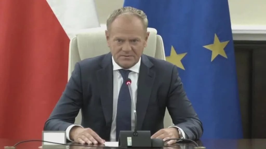 a man in a suit and tie is sitting at a desk