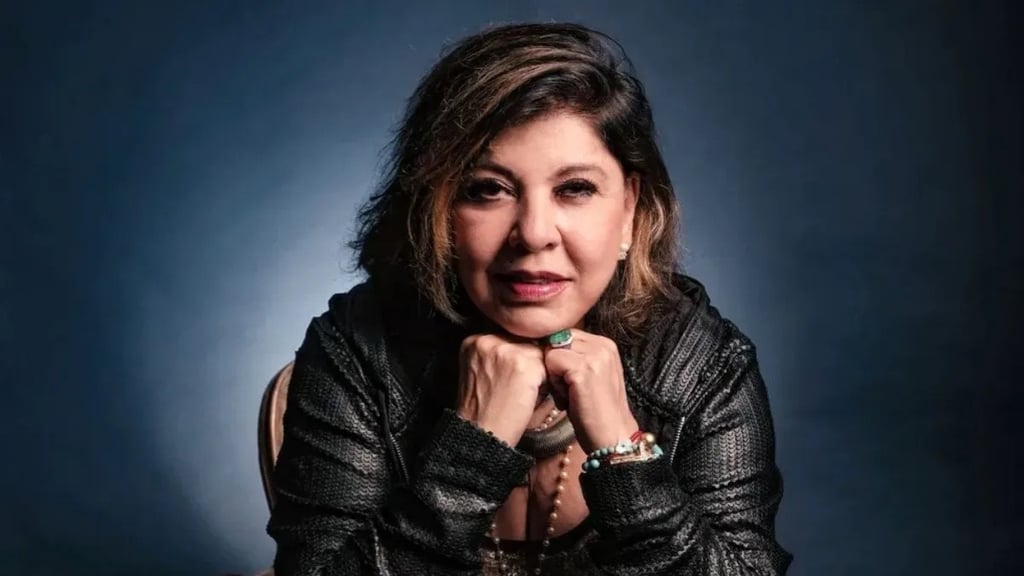 Roberta Miranda com uma jaqueta preta, olhando para a câmera com as mãos no queixo.