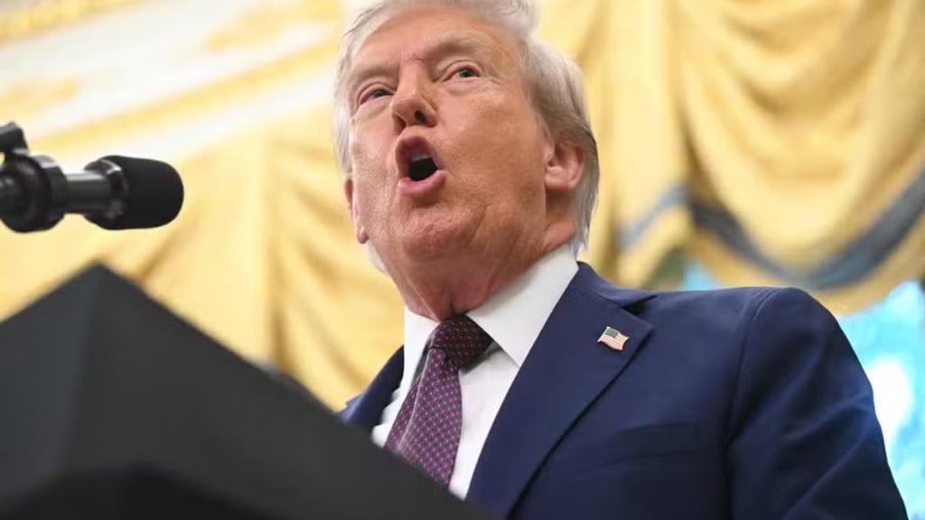 a man in a suit and tie is speaking into a microphone