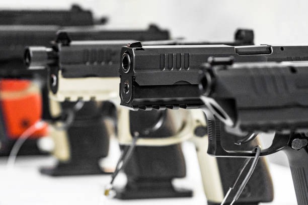 pistols in a row and on display at a gun show booth