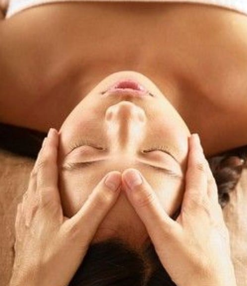 dedos pulgares sobre la frente para empezar masaje facial