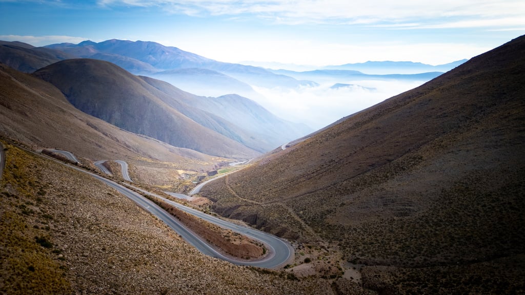 a winding road in the mountains with a view of the mountains