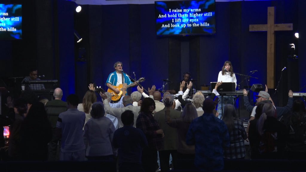 a group of people standing in front of a cross