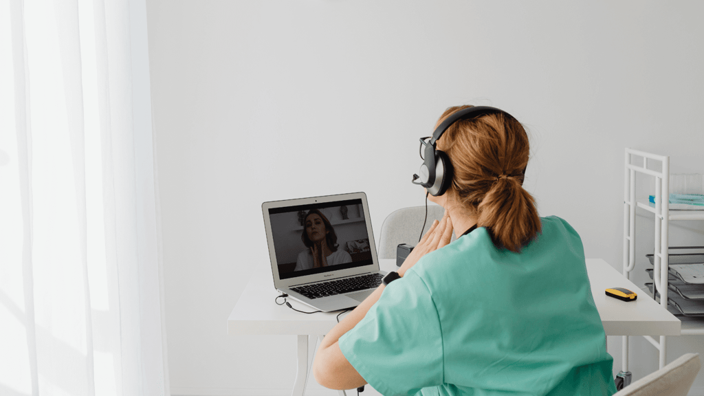 a woman in a green robe is sitting at a desk with a laptop computer