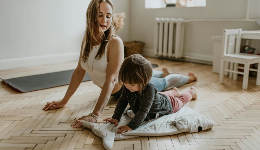 a woman and her daughter playing with a pillow