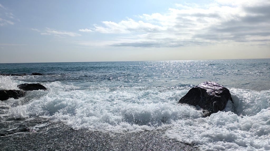 Photo d'océan au Japon, ciel bleu et rocher, vagues sur la place, Aurélie, coach pour femmes à Bxl