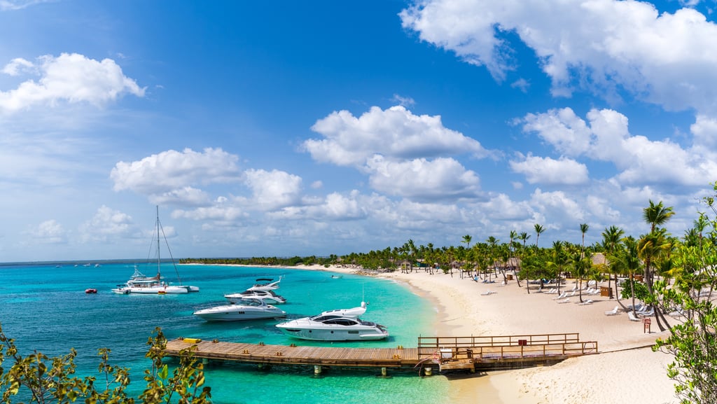 Catalina Island beach with white sand, palm trees, turquoise water, and luxury boats in the Dominican Republic