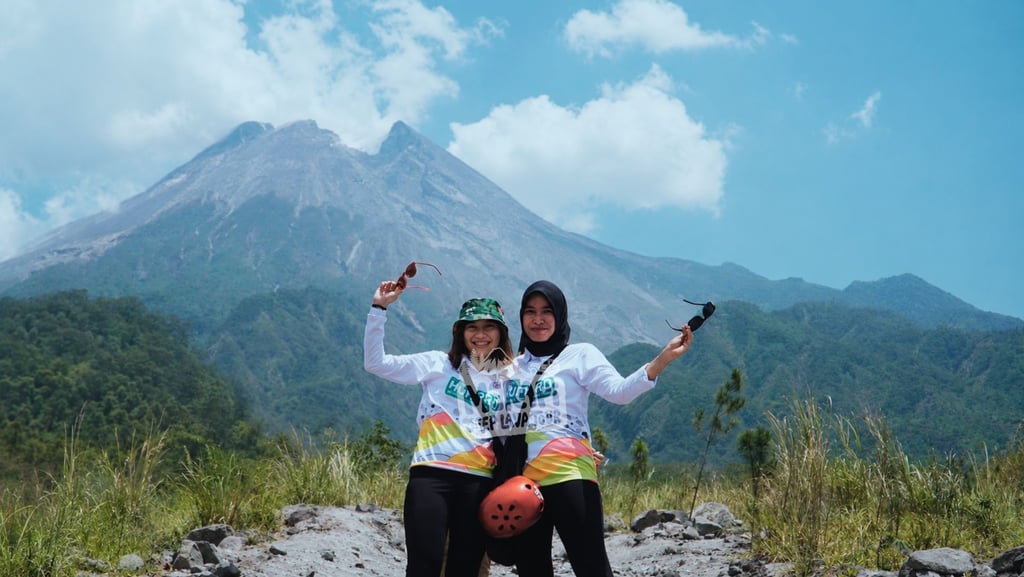 Keluarga menikmati Jeep Merapi bersama anak dengan latar Gunung Merapi di Yogyakarta