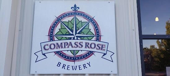 a sign that says compass rose brewing company
