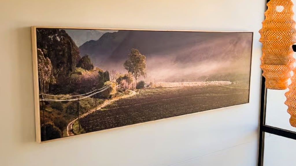 A large panoramic painting of a rural landscape in a modern interior painted by Martin Osner 
