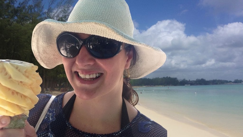 Autora saboreando abacaxi esculpido na praia de Mont Choisy, Port Louis, Ilhas Maurício.