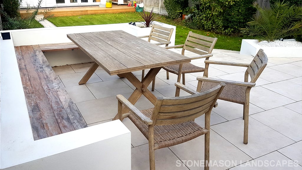 Modern chic raised porcelain patio with white rendered walls and planters