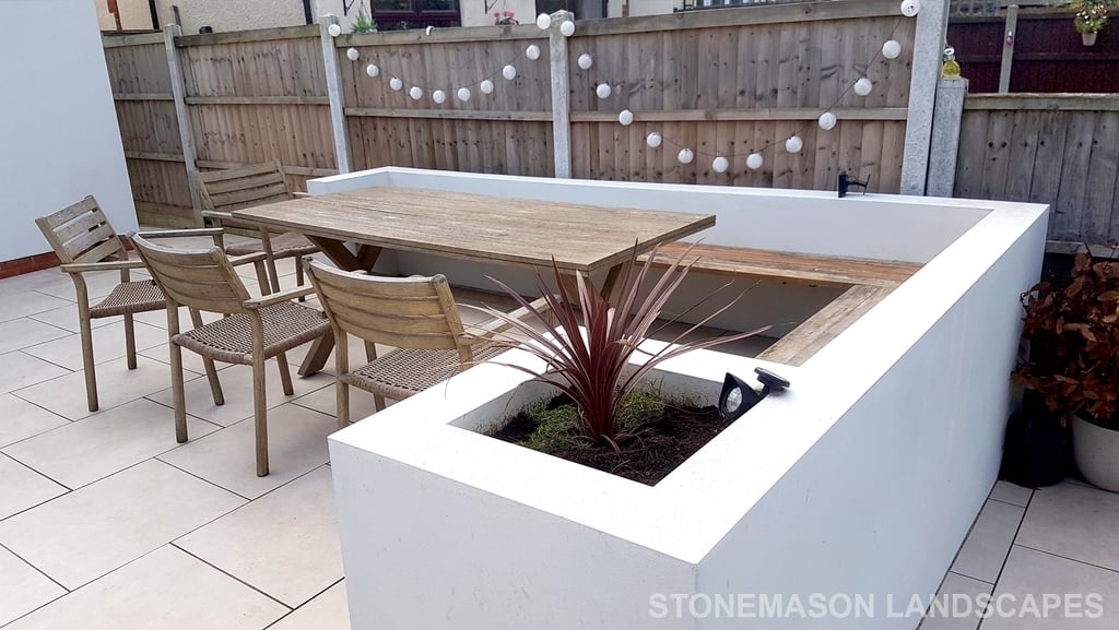 Modern chic raised porcelain patio with white rendered walls and planters