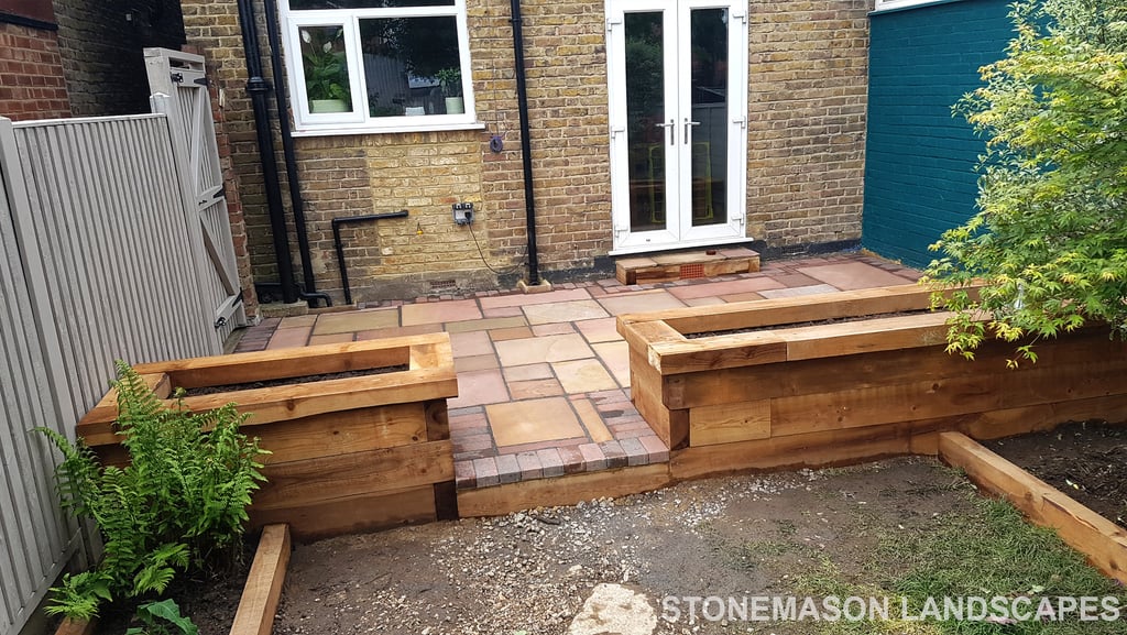 Colourful sandstone patio with raised wooden timber planter seating