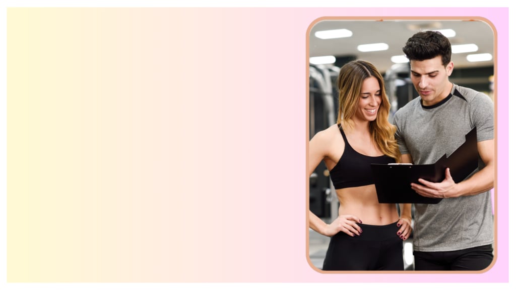 A personal trainer showing a fitness progress chart to a woman in a gym setting.