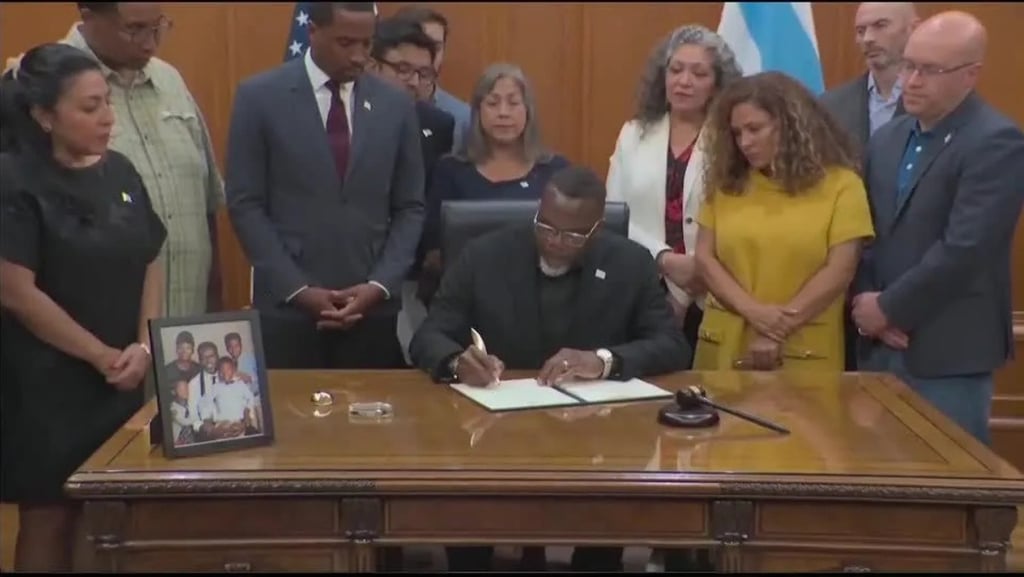 a man in a suit and tie is signing a document