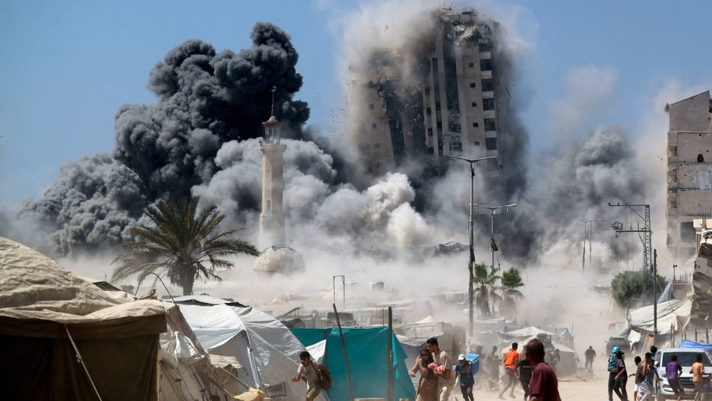 a large black smoke cloud rises over a building