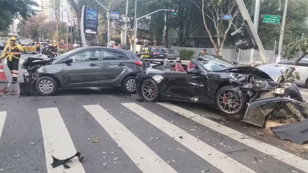 Carro conversível fica destruído após bater em outro veículo e em poste