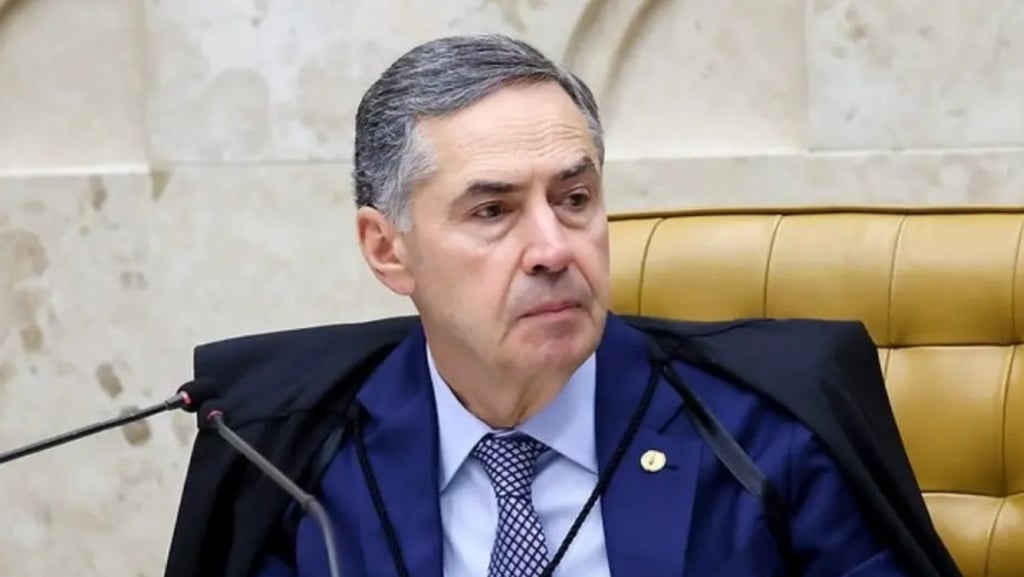 a man in a suit and tie is sitting at a microphone