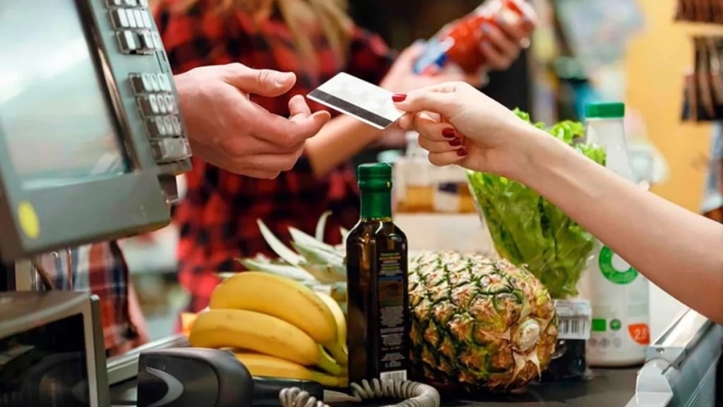 a person is paying a purchase at a grocery store