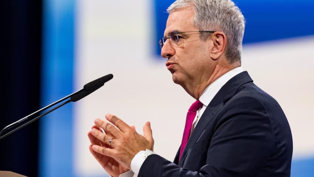 a man in a suit and tie is speaking into a microphone