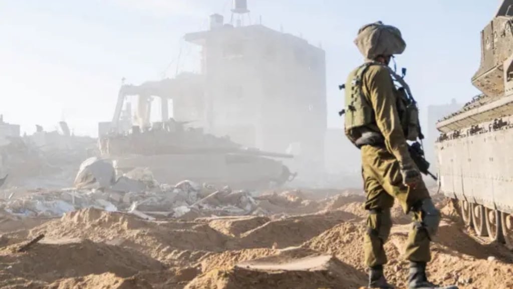 a soldier in uniform stands in front of a tank