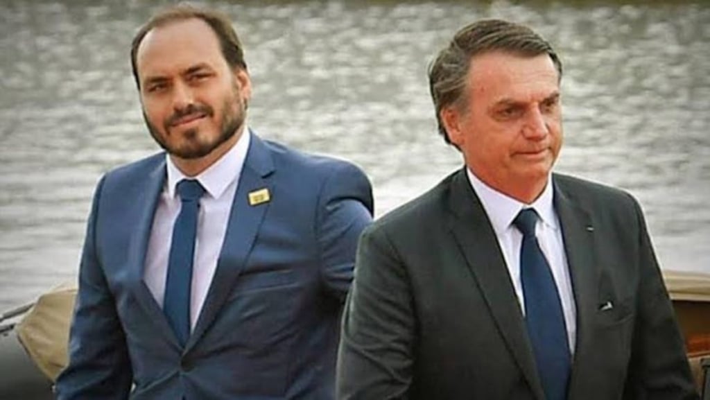 Carlos e Jair Bolsonaro sorrindo em close