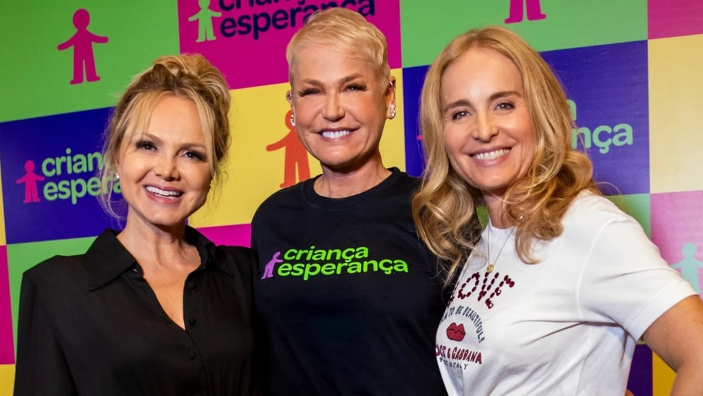  Angélica, Xuxa e Eliana juntas, posando e sorrindo para a câmera.