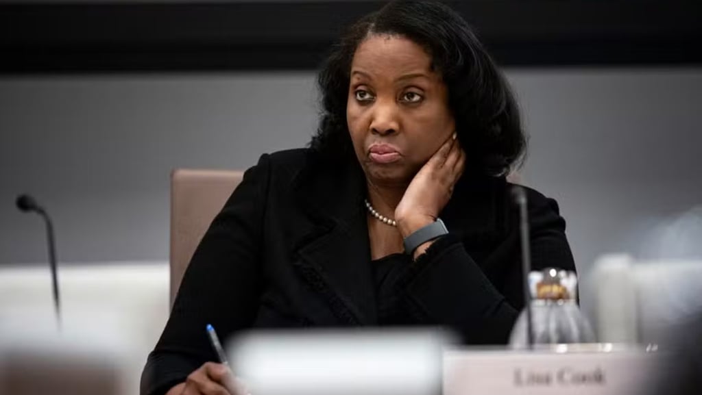 Lisa Cook, com um colar de pérolas, sentada em uma reunião com uma expressão séria.