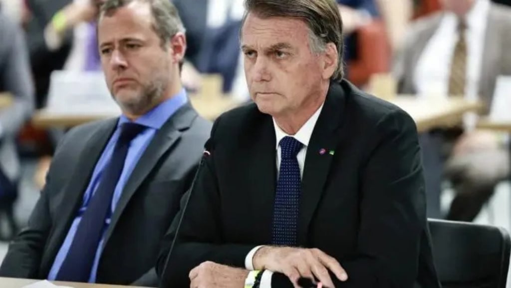 a man in a suit and tie sitting at a table