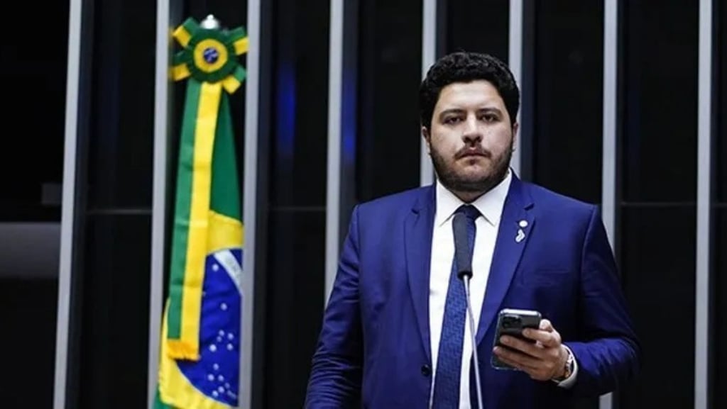 Jadyel Alencar em close segurando um celular.