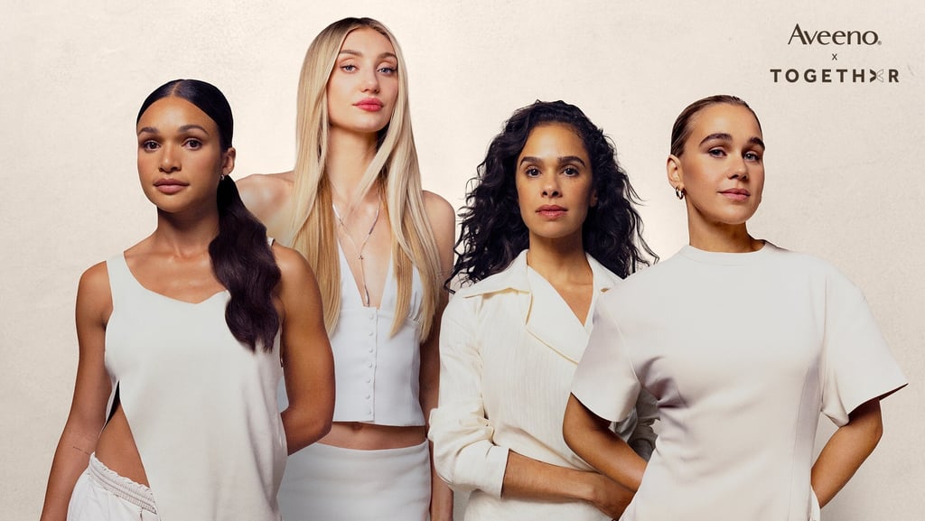 Four diverse women posing in white outfits for an Aveeno skin care campaign brand collaboration.