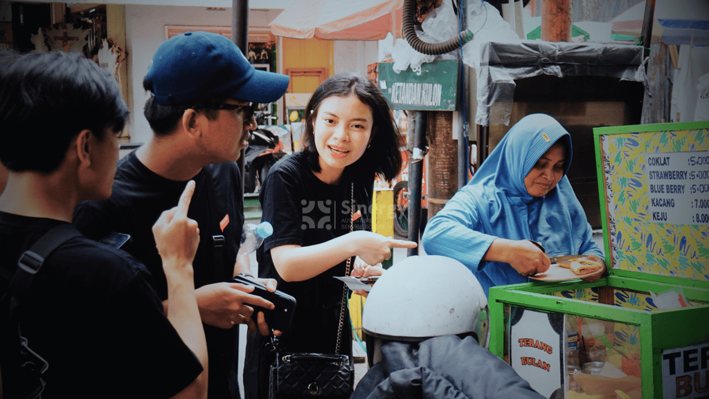Peserta Amazing Race Yogyakarta berinteraksi dengan pedagang di Malioboro.