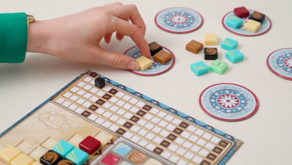 Ranka ima žaidimo plyteles, šalia padėta žaidėjo lenta