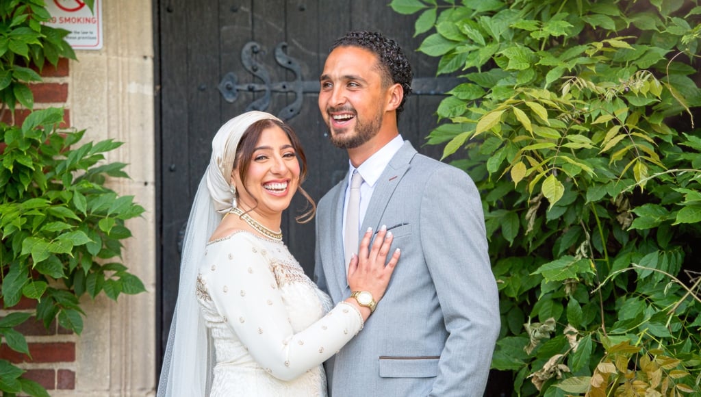 candid photo of bride and groom in front of stately home laughing and smiling