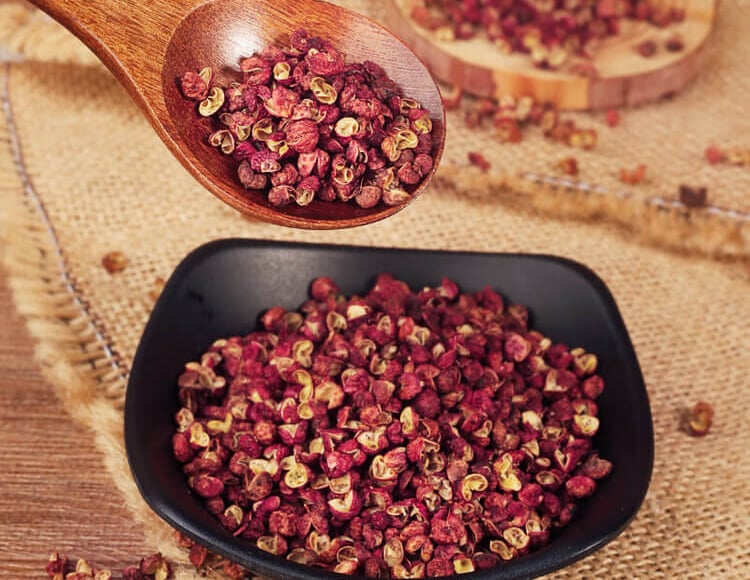 a spoonful of dried premium Sichuan peppercorn in a bowl