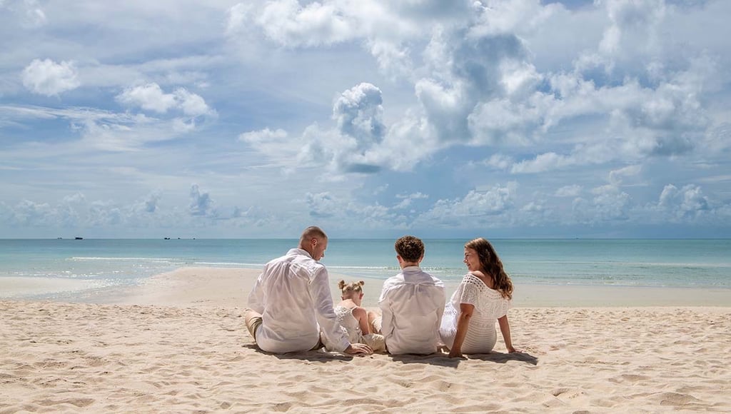 Family sitting together on Khem Beach in Phu Quoc