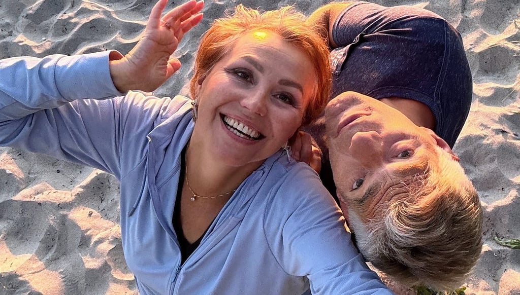 Smiling couple enjoying sunset on the beach, radiating joy, love, and playful connection.