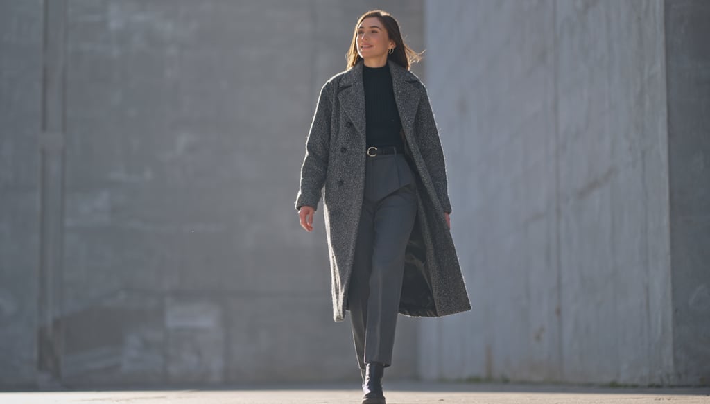 a woman in a coat and a coat over a black coat