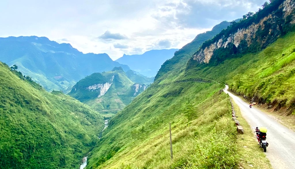 a motorcycle rider riding down a mountain side