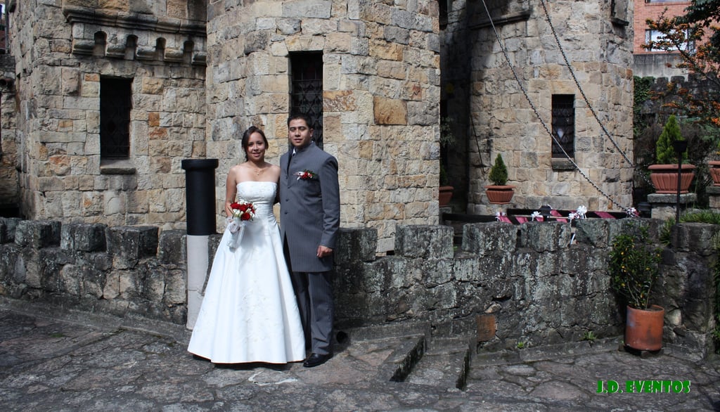 a bride and groom standing in front of a castle
