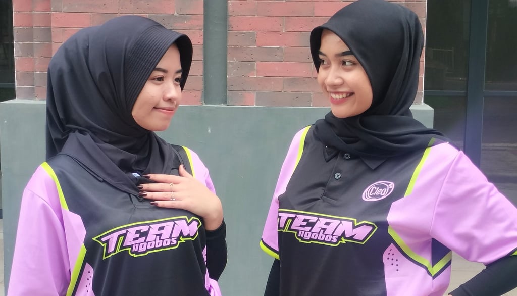 two women in hijab clothing standing next to each other
